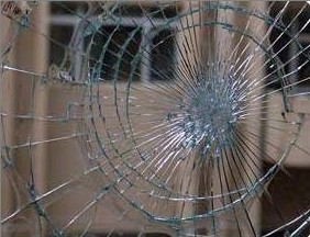 Shattered glass in window with spiderweb crack pattern
