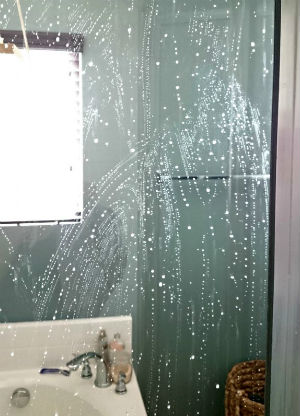 Water droplets on a glass shower panel in a bathroom