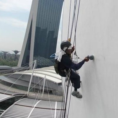 Rope-access worker cleaning a high-rise building wall