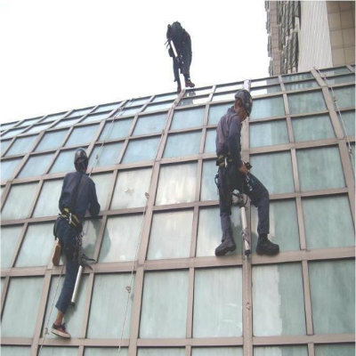 Workers climbing and cleaning a glass building exterior