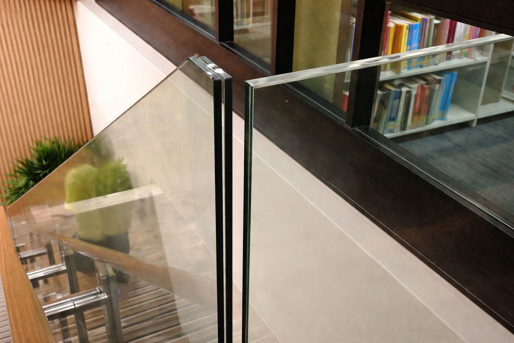 Glass stair railing with metal brackets in modern interior