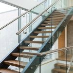 Modern staircase with glass railing and metal handrails